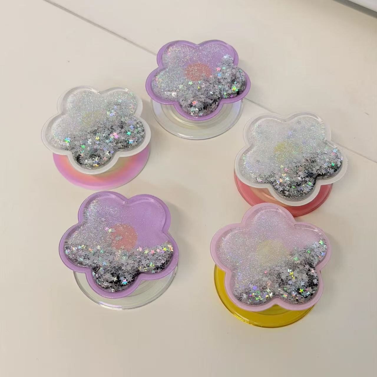 Magnetic translucent purple and pink resin flower MagSafe phone grip with floating holographic star glitter and collapsible stand.
