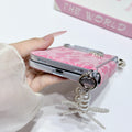 Bottom close-up view of hot pink lace case for iPhone DUO showing precise speaker cutouts, charging port opening, and metal strap rings.