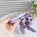 Bottom profile close-up of the lavender polka dot case for iPhone DUO displaying precise USB-C charging port opening, speaker cutouts, and silk scrunchie attachment.