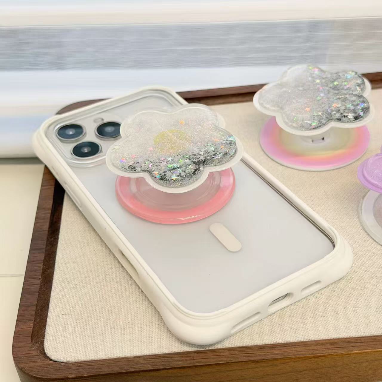 Close-up macro shot of a clear liquid glitter quicksand phone socket in a flower shape showing shimmering silver star confetti and iridescent pastel base.