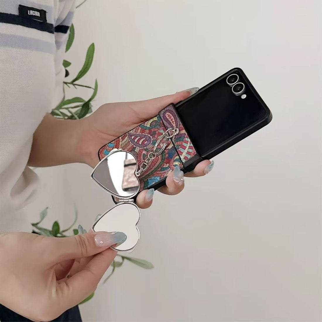 our colors of paisley textured Samsung Galaxy Z Flip cases displayed on a table in brown, multi-color, green, and charcoal gray with heart mirrors.