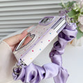 Close-up side angle of the lavender polka dot case for iPhone DUO highlighting the dual-section frame construction, rhinestone heart vanity mirror, and attached purple silk scrunchie.