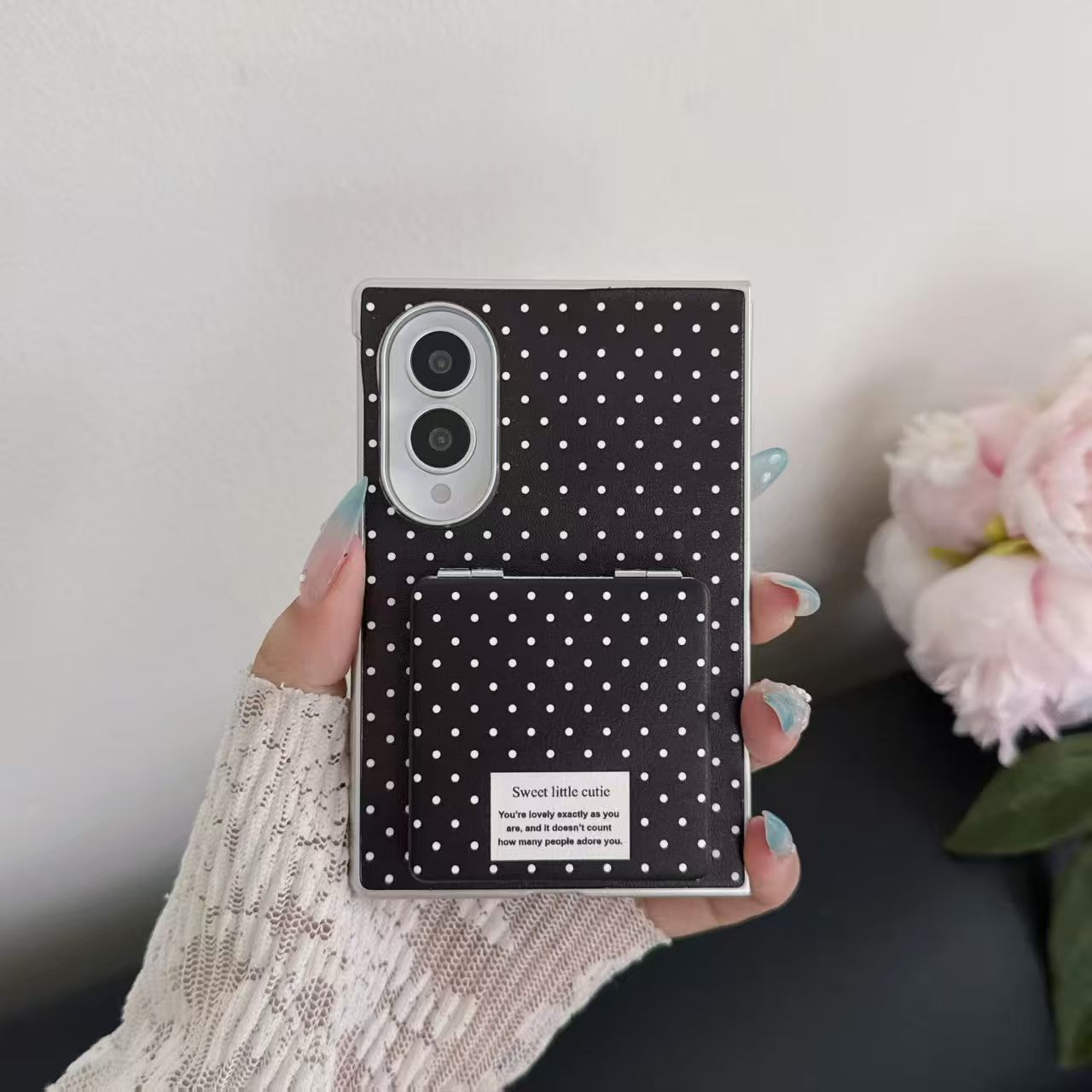 Close-up view of hand holding the black polka dot Samsung Galaxy Z Fold 8 case with built-in compact mirror cover.