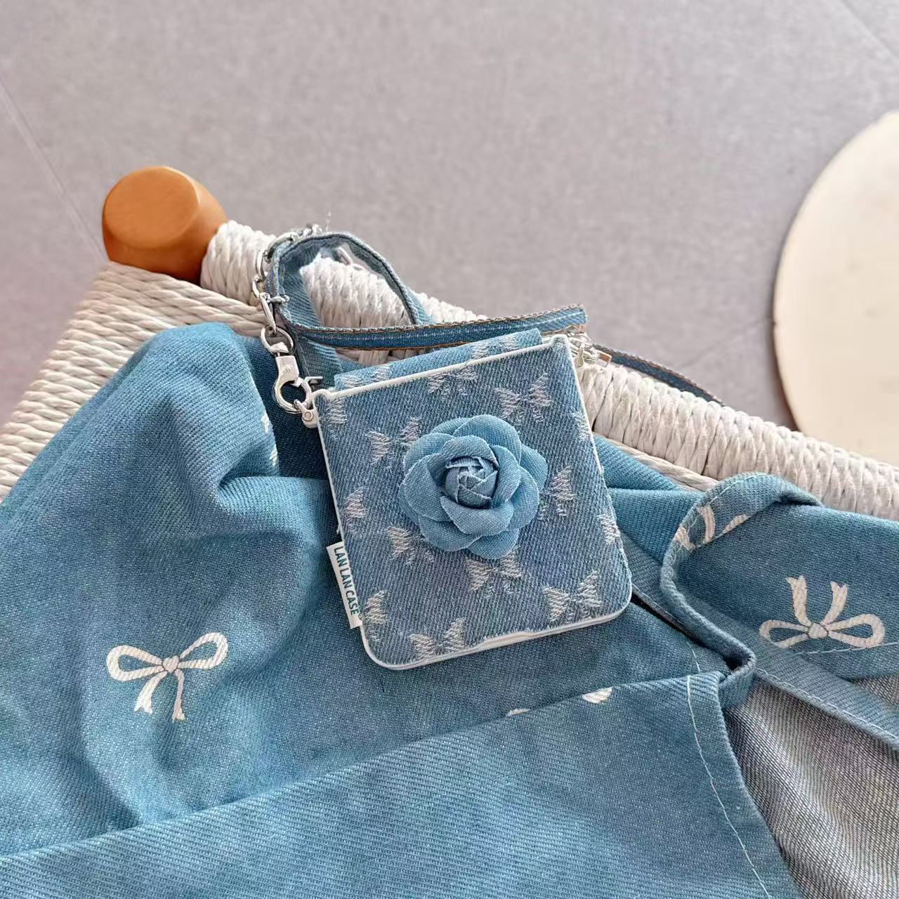 Denim camellia flower Z Flip phone case displayed on matching denim fabric with bow details.
