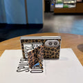 Folded Samsung Galaxy Z Fold standing horizontally with leopard print case and open flip makeup mirror kickstand