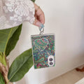 Hand holding a black and white monochrome paisley tapestry Samsung Galaxy Z Fold 8 case with silver heart mirror charm.