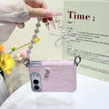 Light pink lace phone cover for iPhone DUO suspended by its pearl chain strap featuring a beaded bow accent and rhinestone charm.