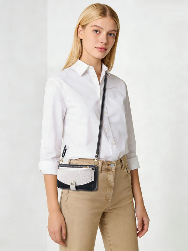 Model wearing the two-tone leather iPhone case with an adjustable long shoulder strap across the body.