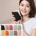 Model holding the black dual-tone leather iPhone DUO wallet case alongside a color palette showcase of all 10 available color options.