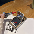 Open leopard print flip mirror phone case for Samsung Galaxy Z Fold resting on table with lipstick reflection in compact mirror