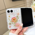 Open view of a hand holding the clear iPhone DUO case showcasing the full real pressed dry flower and wildflower arrangement alongside the active display screen.