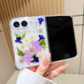 Open view of a hand holding the clear iPhone DUO case showcasing the full real pressed flower garden arrangement alongside the main display screen.