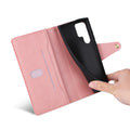 Open view of soft rose pink leather wallet case showing flexible inner black TPU shell being adjusted by hand.
