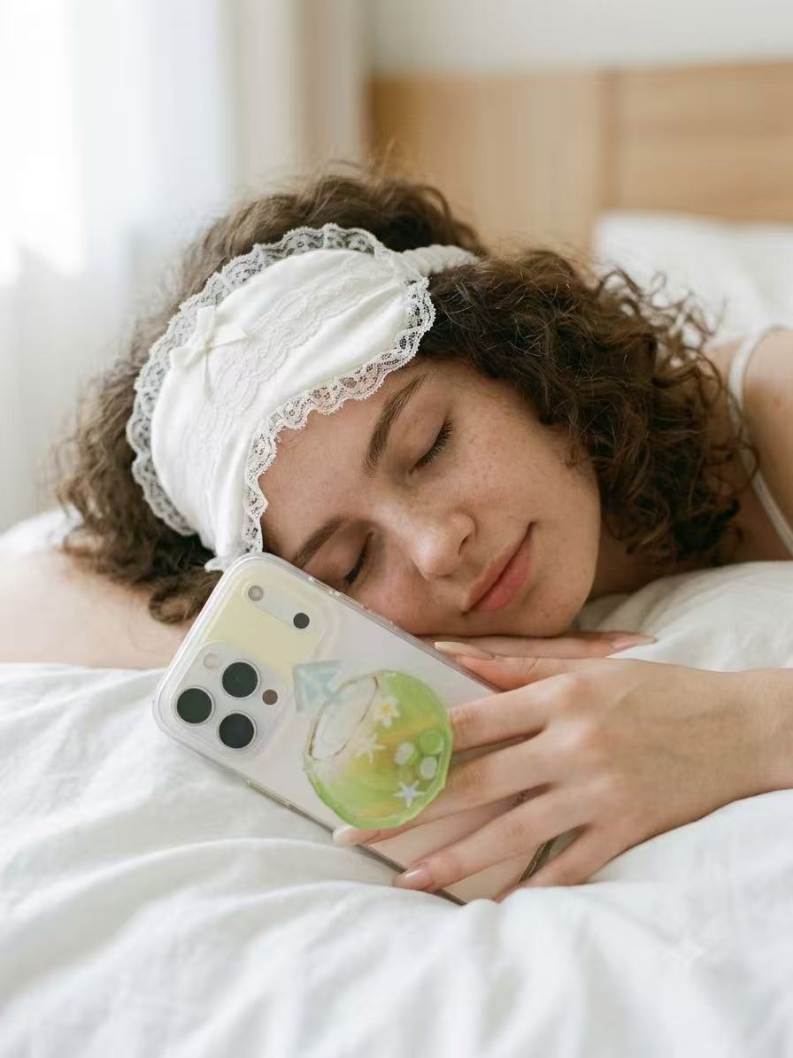 Person holding smartphone with green tropical coconut drink liquid shaker grip featuring 360 degree rotation feature