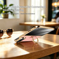 Pink iPhone DUO leather case resting on wooden table using 2-in-1 gold ring as desktop viewing kickstand