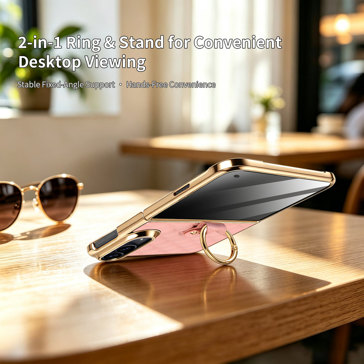 Pink iPhone DUO leather case resting on wooden table using 2-in-1 gold ring as desktop viewing kickstand