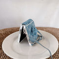 Samsung Z Flip standing in flex mode on a ceramic plate protected by a blue denim flower wrist strap case.