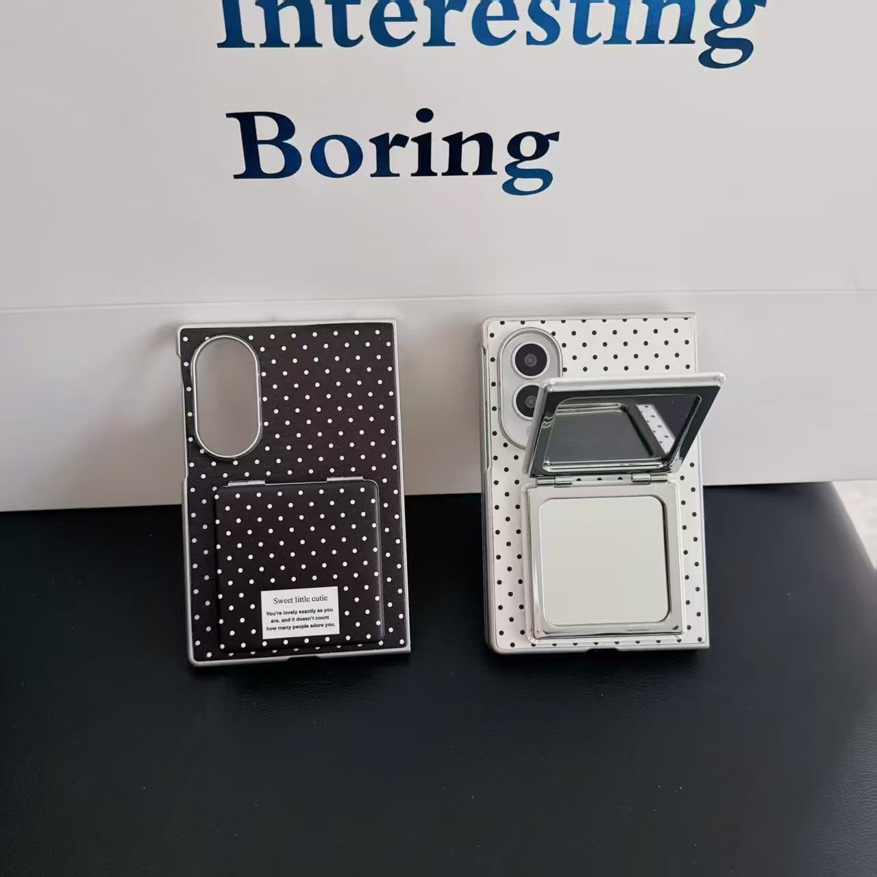 Side-by-side comparison of black and white polka dot Samsung Z Fold 8 cases with one mirror closed and one mirror open.