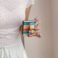 Side view of hand gripping a folded Samsung Z Flip phone using the integrated colorful flower hand strap