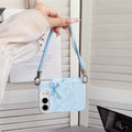 Sky blue marble swirl case for iPhone DUO carried as a handbag wristlet showing the rear marble texture, pearl heart bow charm, and leather-accented pearl strap.