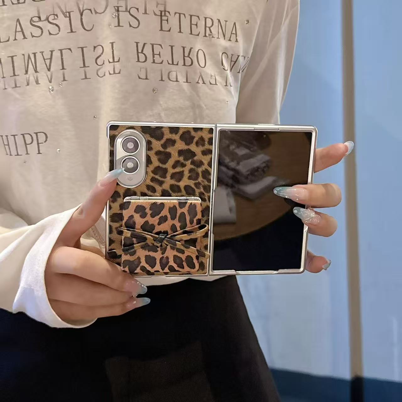 Unfolded Samsung Galaxy Z Fold held open showing main inner display and leopard print vanity mirror case back