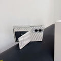 White polka dot Samsung Z Fold 8 case resting horizontally on its open flip mirror used as a kickstand.