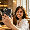 Woman holding black luxury quilted leather Samsung Galaxy Z Fold 8 case with gold ring holder taking a selfie