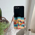 Woman holding an open Samsung Galaxy Z Flip wearing a retro striped case with a colorful flower hand strap.⁠