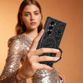 Woman in a shimmering dress holding a Samsung Galaxy Z Fold in a black glitter case using the integrated ring grip.