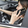 Woman making a phone call in a car holding black chevron leather Samsung Galaxy Z Fold case with gold ring